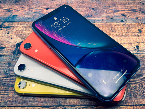 A composição da tela frontal do iPhone XR foi utilizada com diversas variações de cores, dispostas sobre a mesa.