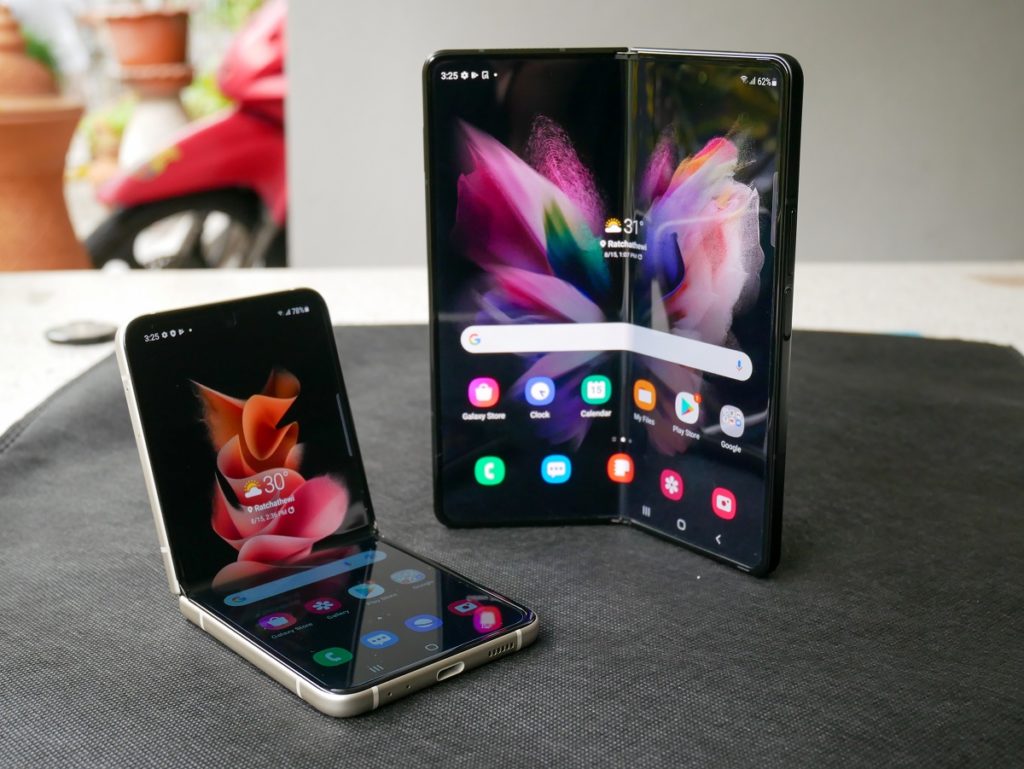 Dois aparelhos Galaxy Flip3, ambos pretos sobre uma mesa.O da esquerda está sobrado na horizontal e o direita na vertical.