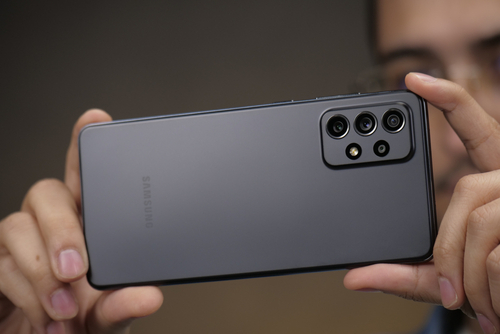 Homem tirando uma foto com câmeras Samsung Galaxy A72, smartphone de médio porte.