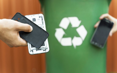 Foto ilustrativa sobre reciclagem, com celulares desmontados no canto da tela. 
