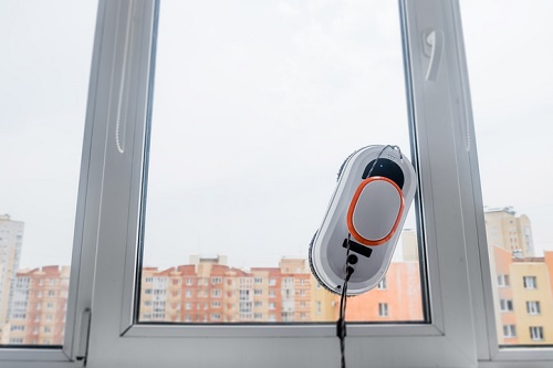 O limpador de janelas do robô trabalha na janela suja. Limpando a casa com dispositivos inteligentes. Robôs aspiradores automáticos para limpeza de vidros, um assistente para a casa.