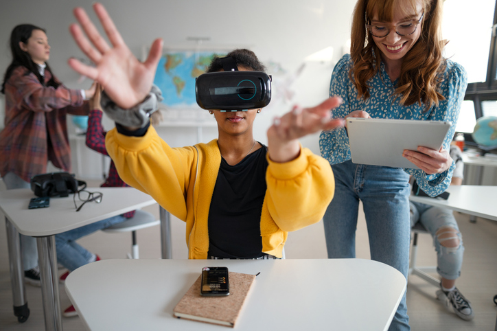 Alunos adolescentes usando óculos de realidade virtual na escola em uma aula de ciência da computação.