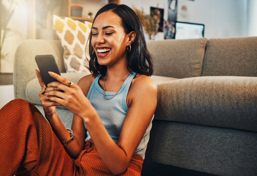 Imagem mostrando uma mulher usando um smartphone, representando o que são gadgets.