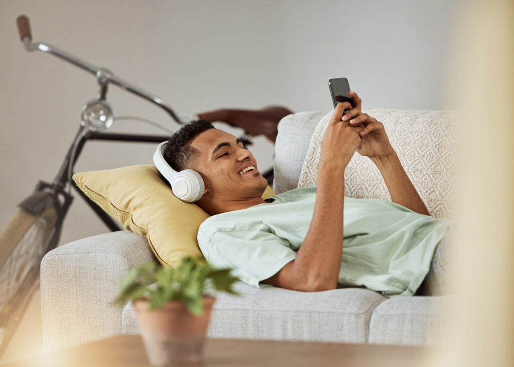 Imagem mostrando um homem assistindo vídeo no celular, representando o melhor aplicativo para baixar vídeo.