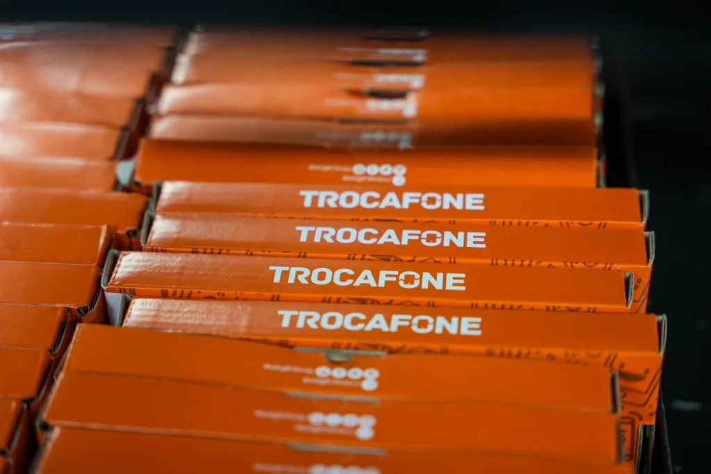 Caixas laranjas empilhadas com a marca Trocafone impressa em branco para conteúdo sobre melhor site para vender celular usado